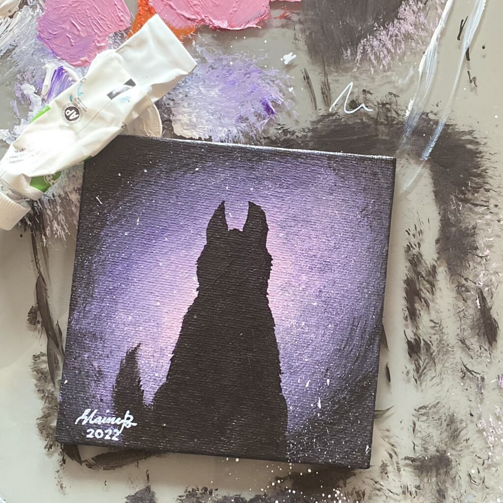 Silhouette of a husky against purple galaxy light.
