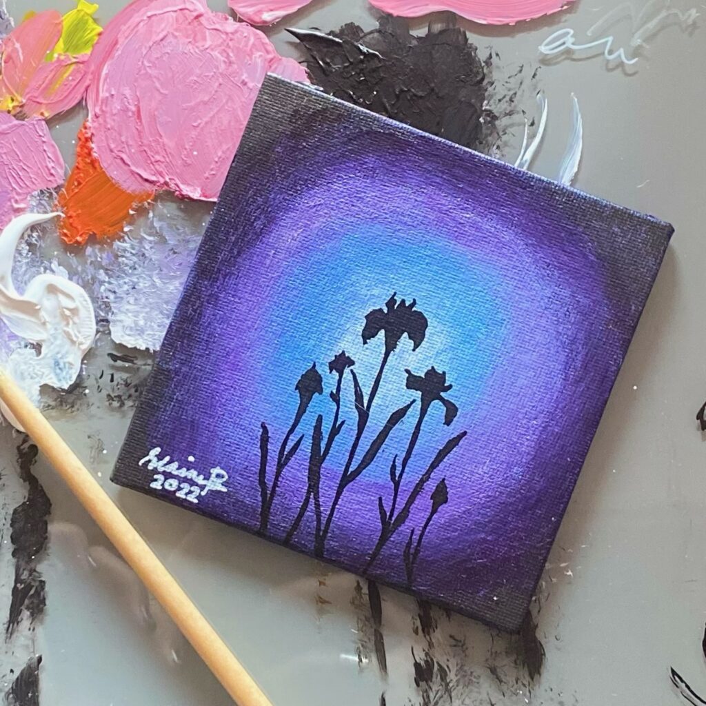 Silhouette of iris flowers against purple light.