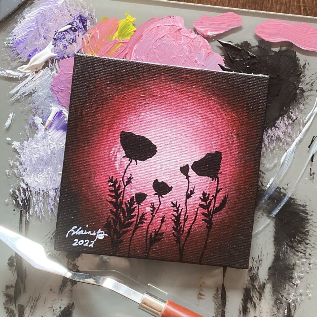 Silhouette of poppies against red light.
